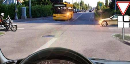 Which vehicle must you give way to if you intend to continue driving straight ahead?